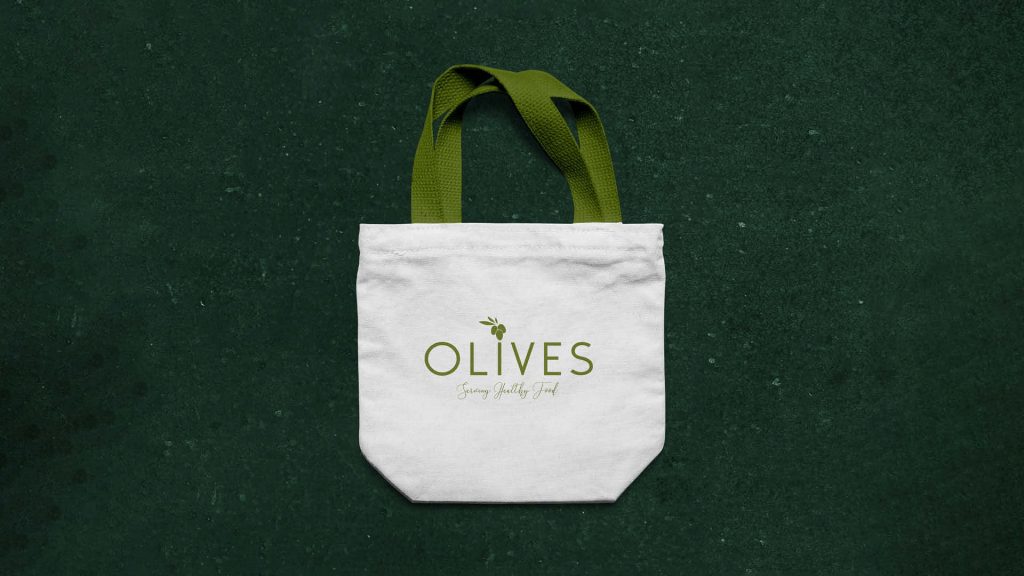 Tote bag mockup featuring a restaurant logo with an olive design, perfect for demonstrating eco-friendly branding.